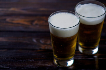 a large glass of cold light beer with foam on a dark background. St.Patrick 's Day