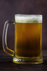a large mug of cold light beer on a dark background. St.Patrick 's Day
