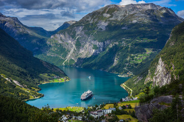 Cruise ships stand in the harbor of the Geiranger fjord, Norway - obrazy, fototapety, plakaty