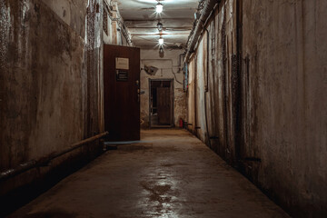 Fototapeta na wymiar A beautiful corridor with shabby walls in an abandoned underground bunker. Old underground building. Shabby walls. Low light.