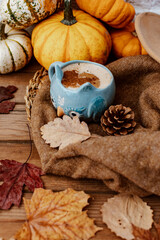 Obraz na płótnie Canvas Autumn composition with coffee, autumn leaves, warm sweater and pumpkins on wooden background, Autumn still life, Autumn, fall, halloween, thanksgiving day concept.