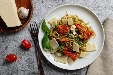 Spaghetti with avocado cream, tomatoes and parmesan. Vegetarian dish.