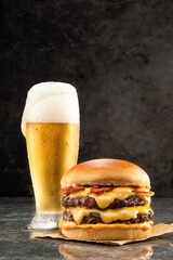 Hamburger with beer on stone table