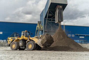 A loader is waiting for a dump truck near the filtration shop.