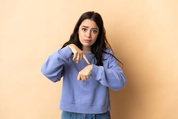 Young caucasian woman over isolated background making the gesture of being late