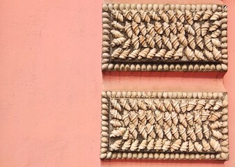 Pink wall with white sea shells decoration with space to write your text 