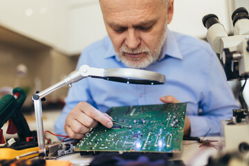 Engineer fixing broken computer motherboard. Electronic repair shop, technology development concept