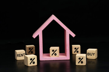 Percentage and Rent, Buy symbol icon on wooden block and wooden house on dark background. Real Estate Benefit Concepts.
