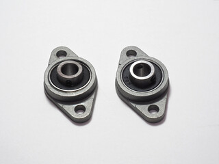 Metal ball bearing in housing. Two bolt flanged housing units. Ball bearings isolated on white