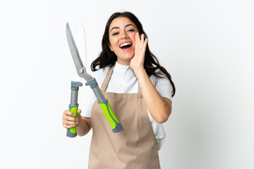 Young caucasian woman holding a plant isolated on white background shouting with mouth wide open