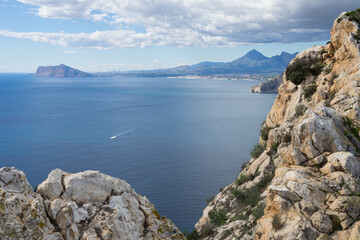 rocks and view of the blue mediterranean sea and mountains near the coast