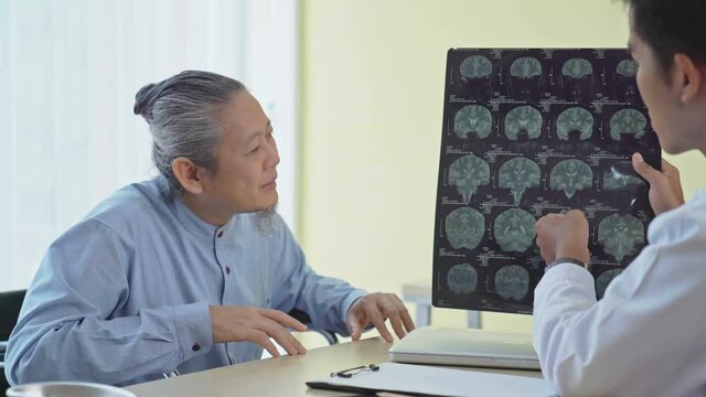 Man doctors discussion with patient's by reviewing a resonance magnetic imaging or x-ray film checking in hospital. Medication , healthcare insurance concept.