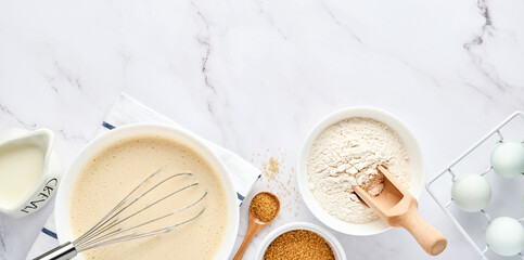 Preparation of dough for home pancakes for Breakfast or for Maslenitsa. Ingredients on the table - wheat flour, eggs, butter, sugar, salt, milk. Recipe step by step. Top view with place for text.