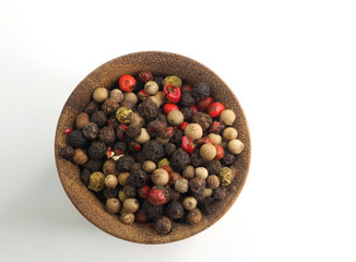 Peppercorns 4 colors in a wooden bowl. View from above
