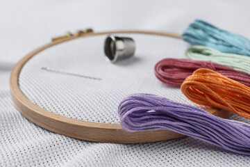 Threads and embroidery hoop with white fabric, closeup © New Africa