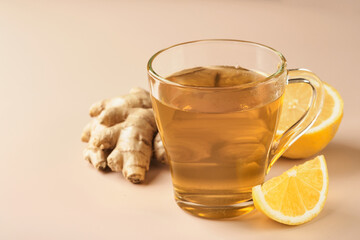 Ginger tea. Cup of ginger tea with lemon, honey and mint on beige background. Concept alternative medicine, natural homemade remedy for cold and flu. Top view. Free space for your text.