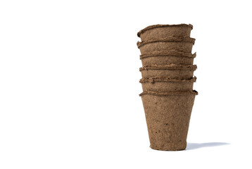 several empty peat pots for seedlings inserted one into the other isolated on a white background