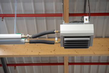 Hot water aerotherm fixed to the ceiling of a modern warehouse