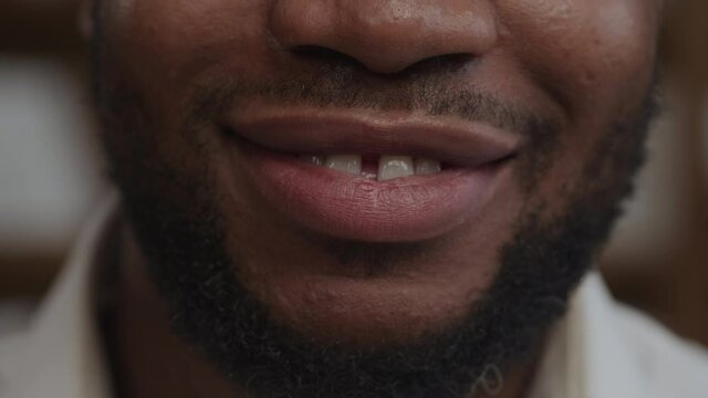 Sincere smile of an adult african-american man in extreme close-up in slow motion