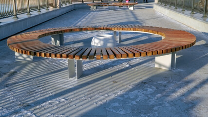 Fototapeta premium Wooden benches in winter park. Wooden bench in the park in the snow in winter.