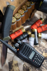 haunting equipment of shotgun cartridge belt, knife, binocular, and radio on the camouflage background