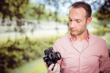 photographer with retro camera look at his vintage machine with old lens and analog film with...