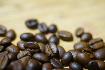 Kaffee Bohnen im Detail auf einem hölzernen Untergrund mit schönem Verlauf der Unschärfe und...