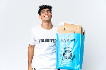 Young man holding a recycling bag full of paper laughing