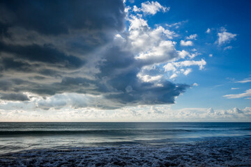 Cloudy seascape view from a beach at sunset