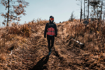  Young traveler hiking girl with backpacks. Hiking in mountains. Sunny landscape. Tourist traveler...