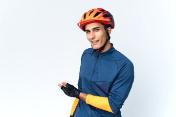 Young cyclist man isolated on background extending hands to the side for inviting to come
