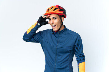 Young cyclist man isolated on background doing surprise gesture while looking to the side