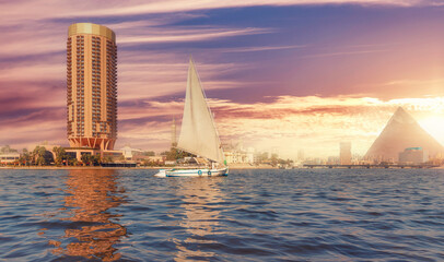 Sunset river Nile with white sailing yacht background egyptian pyramid Cairo, Egypt
