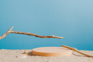 Empty round beige platform podium and dry tree twigs on white beach sand background. Minimal...