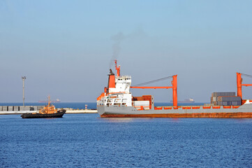 Tugboat assisting bulk cargo ship