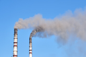 Coal power plant high pipes with black smoke moving upwards polluting atmosphere. Production of...