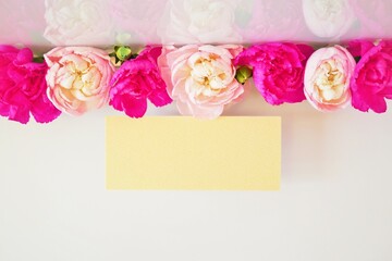 Obraz premium 一列に並んだ赤とピンク色のカーネーションの花を添えた何も書かれていないのカードのモックアップ
