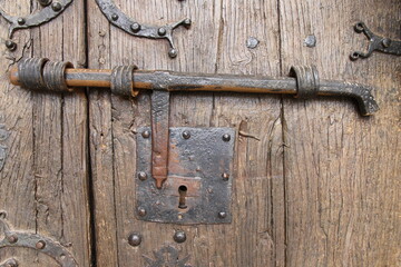 Old metal bolt on a wooden door in a romanesque church in Perazancas, north of Palencia, Spain	