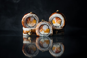 composition of appetizing sushi on black background