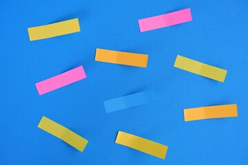 small blank sticker notes in different colors on blue background. Mockup sticky Note Paper. empty...