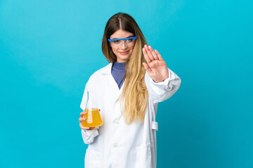 Young blonde scientific woman isolated on blue background making stop gesture