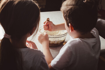 Children mixing dough for baking