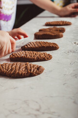 Child hands decorating cookies with a knife