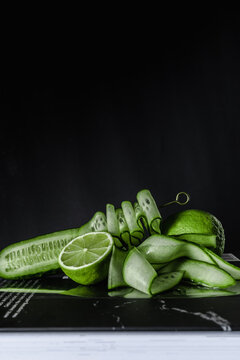 green beans lime cucumber black background