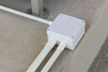 Square Flooring box with plastic pipes and electric cables. White electrical junction box and wires...