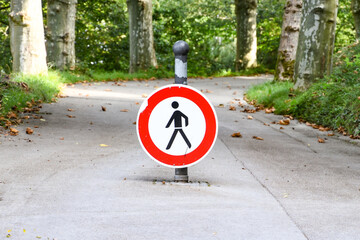 No walking traffic sign in the park, outdoor. Red and white traffic sign.