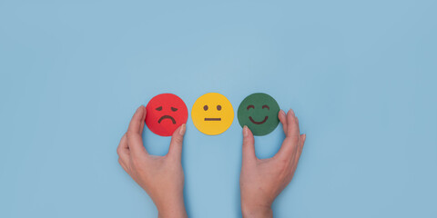 Mental health concept. Hand choosing happy smile face paper cut, good feedback rating and positive customer review, satisfaction survey , mental health assessment, child wellness, world mental health 