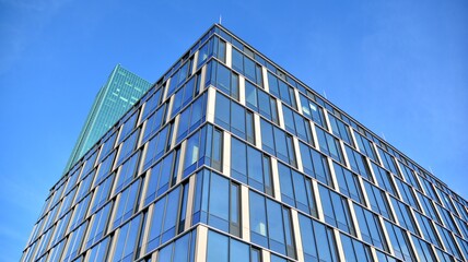 Modern glass corporate architecture with reflection of sky on the facade a sunny day - obrazy, fototapety, plakaty