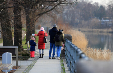 Ludzie, rodzina spaceruje w parku nad rzeką Odrą.