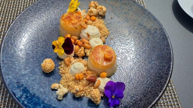 Lemon Creme Brule topped with cream, nuts, caramelized popcorn decorated with summer flowers. 4K